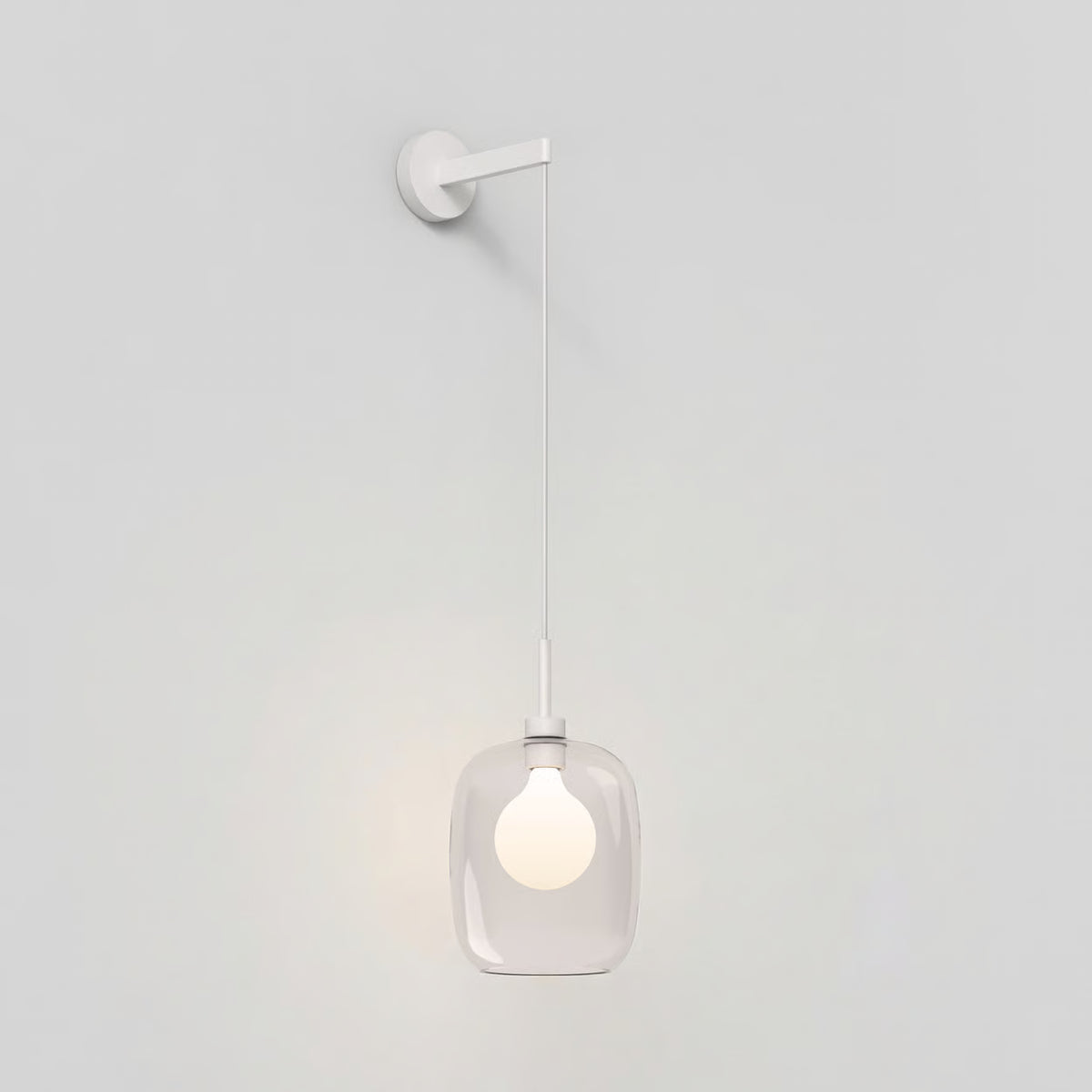 White wall light with a clear glass shade and a glowing bulb