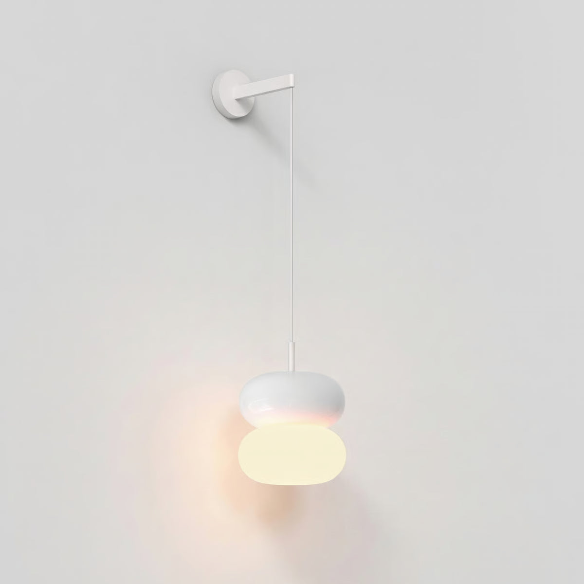 White wall light with two stacked oval shades, the bottom one illuminated