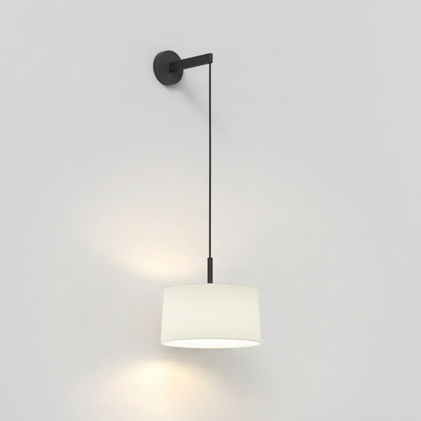 Black wall-mounted pulley with a white drum lampshade hanging from a black cord