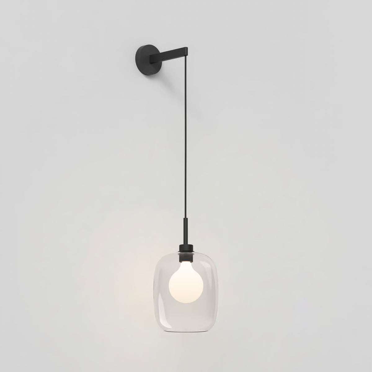 Black wall-mounted light fixture with a clear glass shade and an illuminated bulb