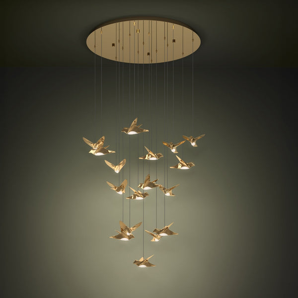 Gold bird-shaped pendant lights hang from a circular gold ceiling fixture against a dark green wall