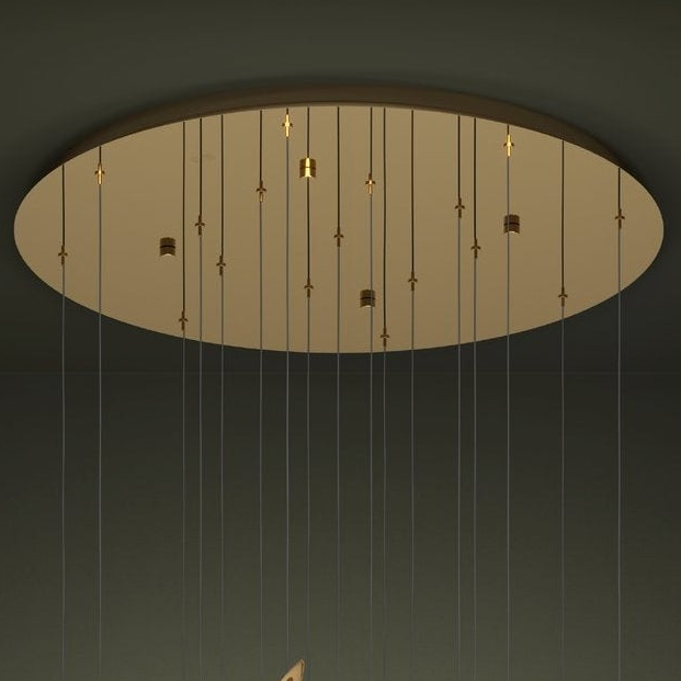 Close-up of the round golden base of a chandelier with multiple hanging wires