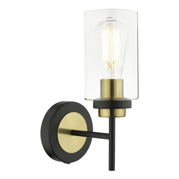 Black and brass wall sconce with a clear glass shade and exposed filament bulb.
