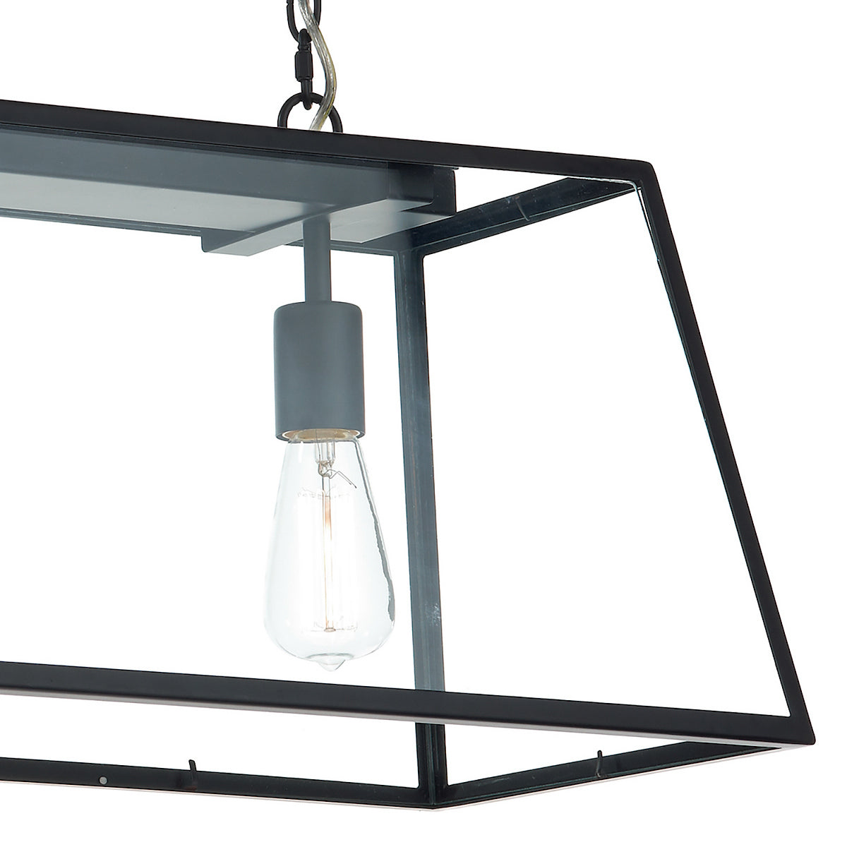 Close-up of a black metal and glass pendant light with an exposed filament bulb.