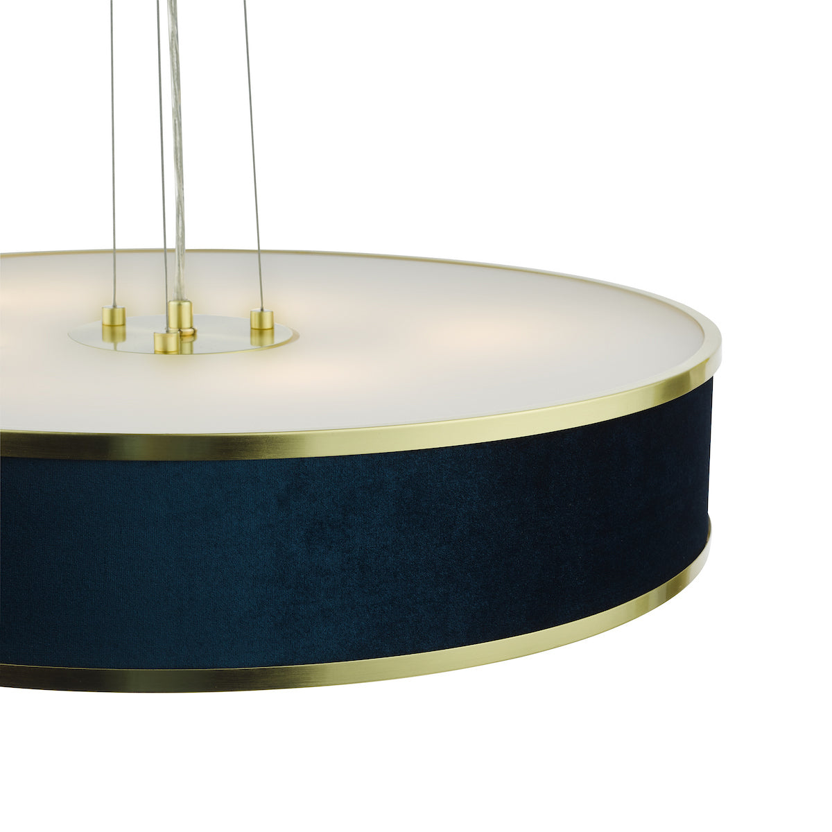 Close-up of a round, dark blue velvet pendant light with gold trim and white diffuser.