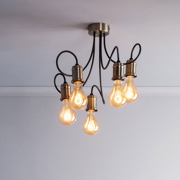 A modern ceiling light fixture with five exposed Edison bulbs and black, curved arms.