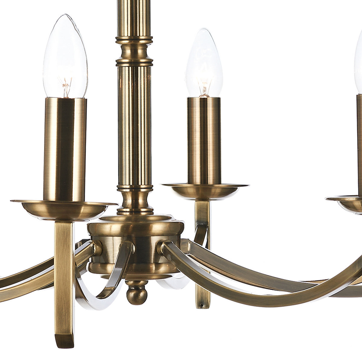 Close-up of a brass chandelier with candle-shaped bulbs and curved arms.