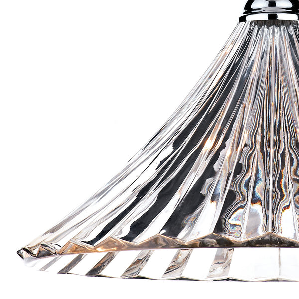 Close-up of a clear, fluted glass lampshade with a chrome top, reflecting light.