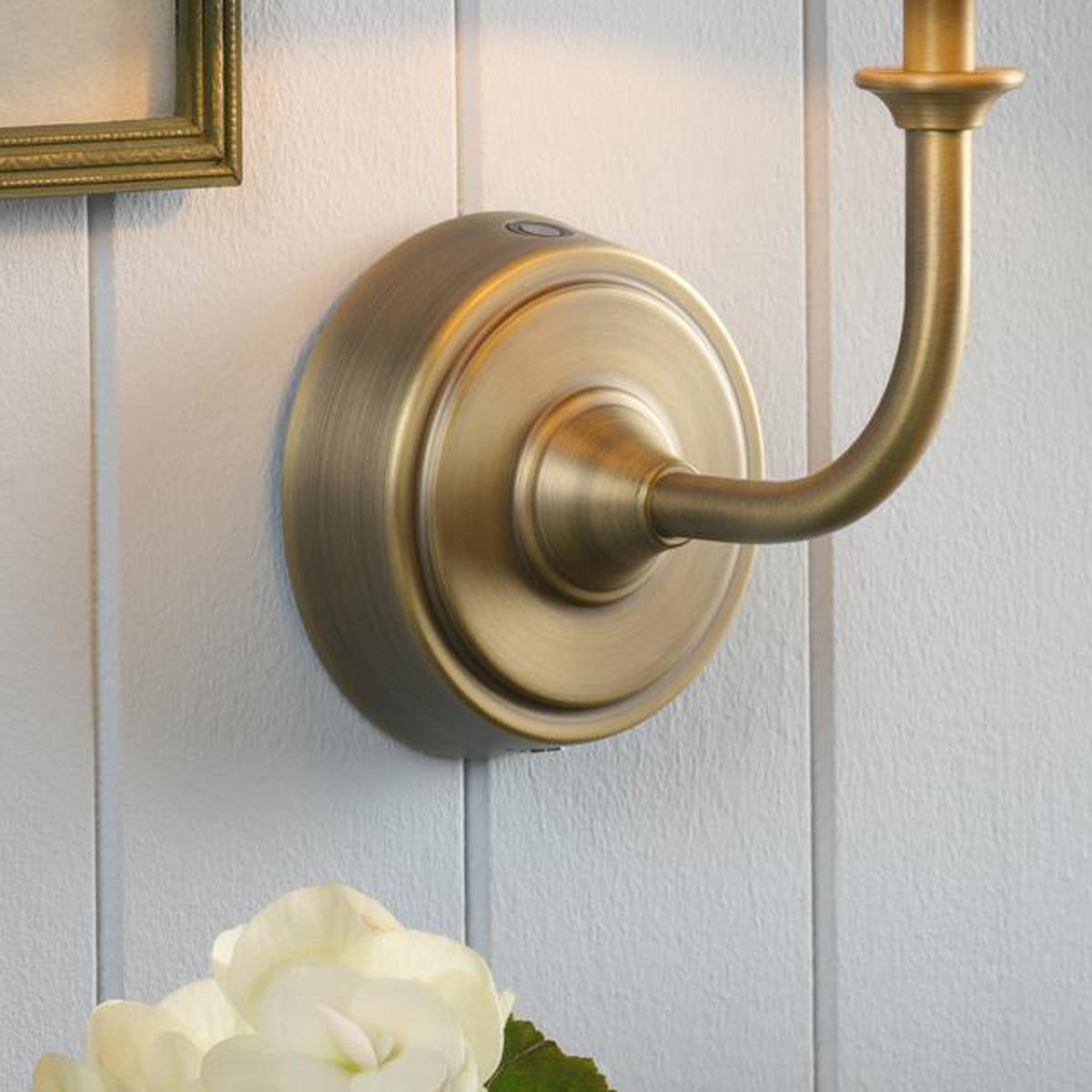 Joules Apsley rechargeable wall light in matt antique brass mounted on white panelled wall