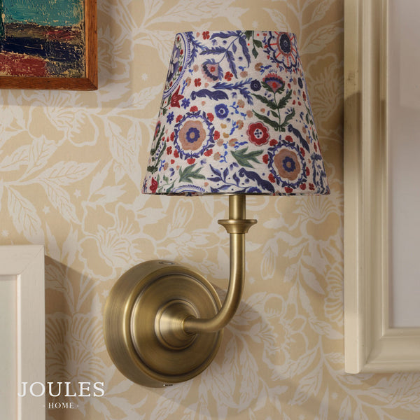 Joules Home wall light with a brass finish and a patterned floral fabric shade