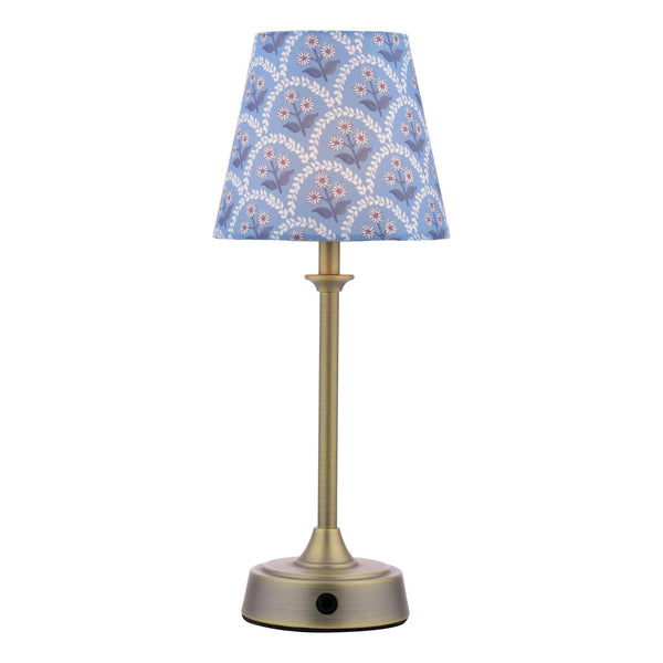Table lamp with a brass base and a blue floral patterned fabric shade