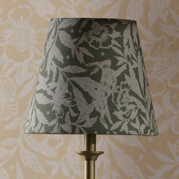 Tapered lampshade with green and white rabbit and floral print on a brass base