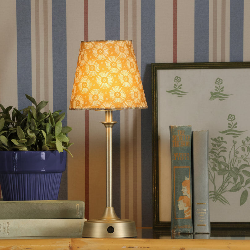Joules Apsley rechargeable table lamp in antique brass with a patterned yellow cotton shade