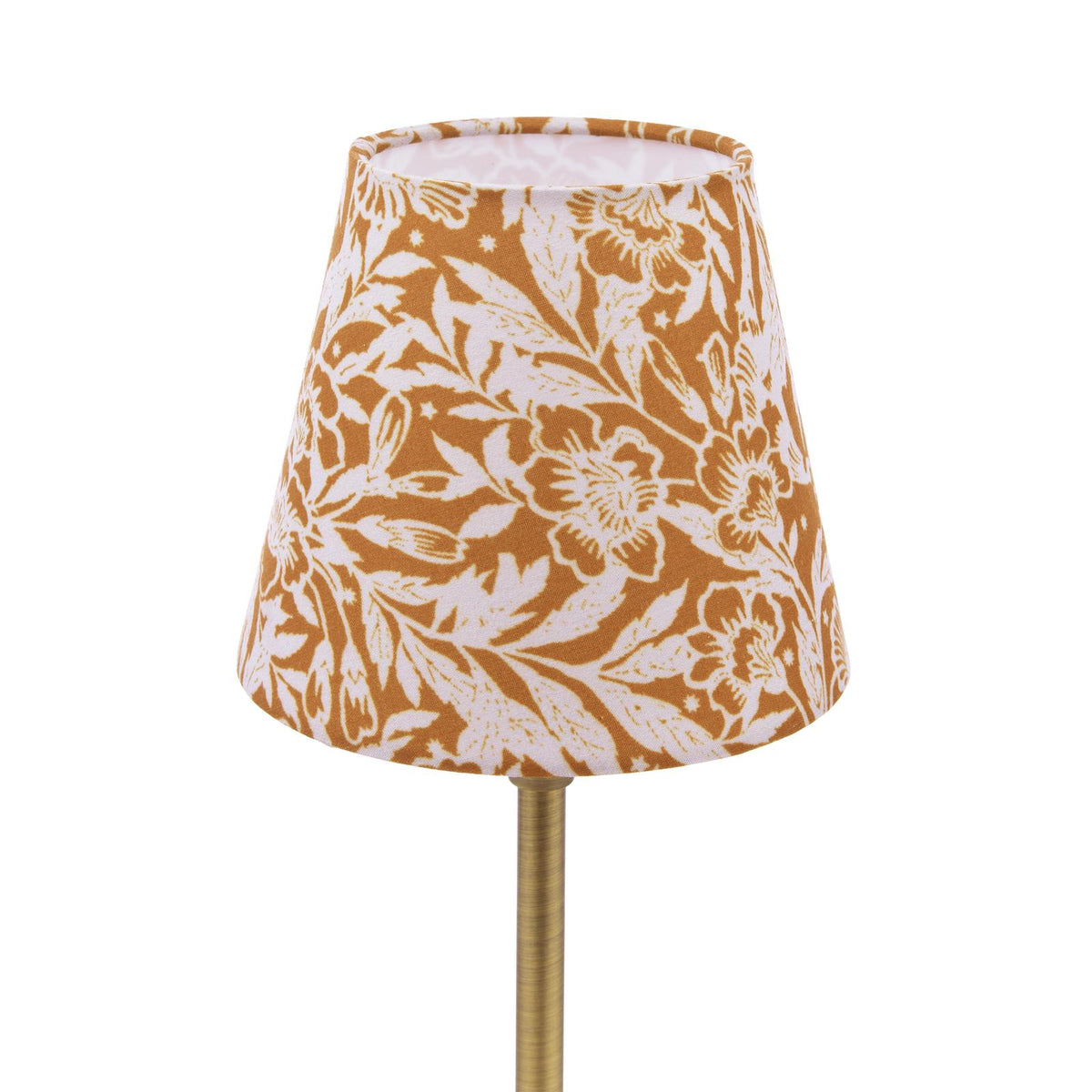 Tapered lamp shade with white and mustard yellow floral pattern on a brass stand