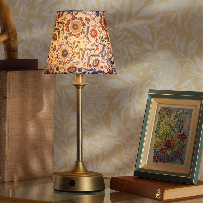 Joules Apsley rechargeable table lamp in matt antique brass with a multi colour floral cotton shade
