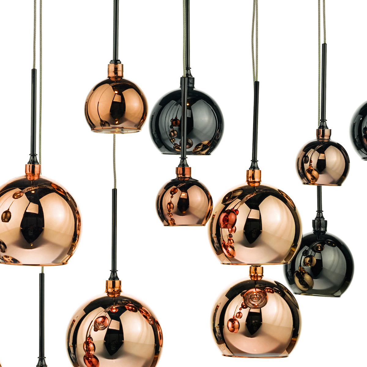 A cluster of pendant lights with copper and dark grey mirrored glass shades.