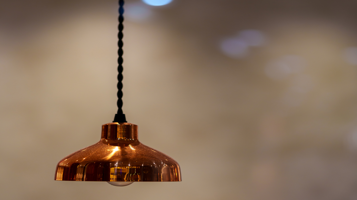 Copper pendant light fixture with a black braided cord