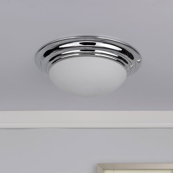 Chrome flush mount ceiling light with a white glass diffuser, installed on a white ceiling.