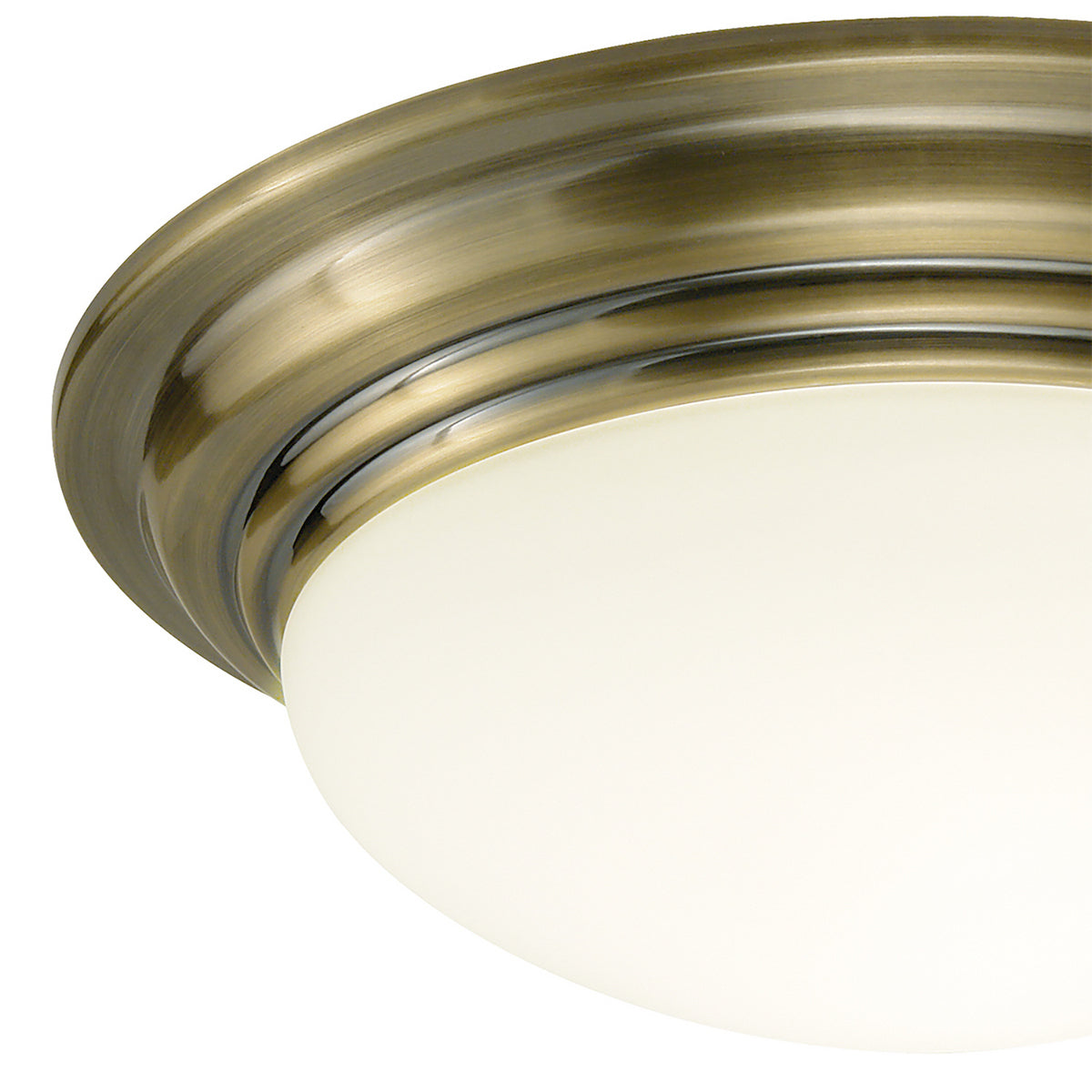 Close-up of a ceiling light with an antique brass finish and a white frosted glass dome.