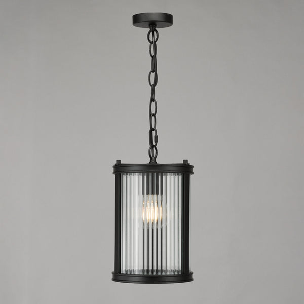 Black metal pendant light with a fluted glass shade and exposed bulb
