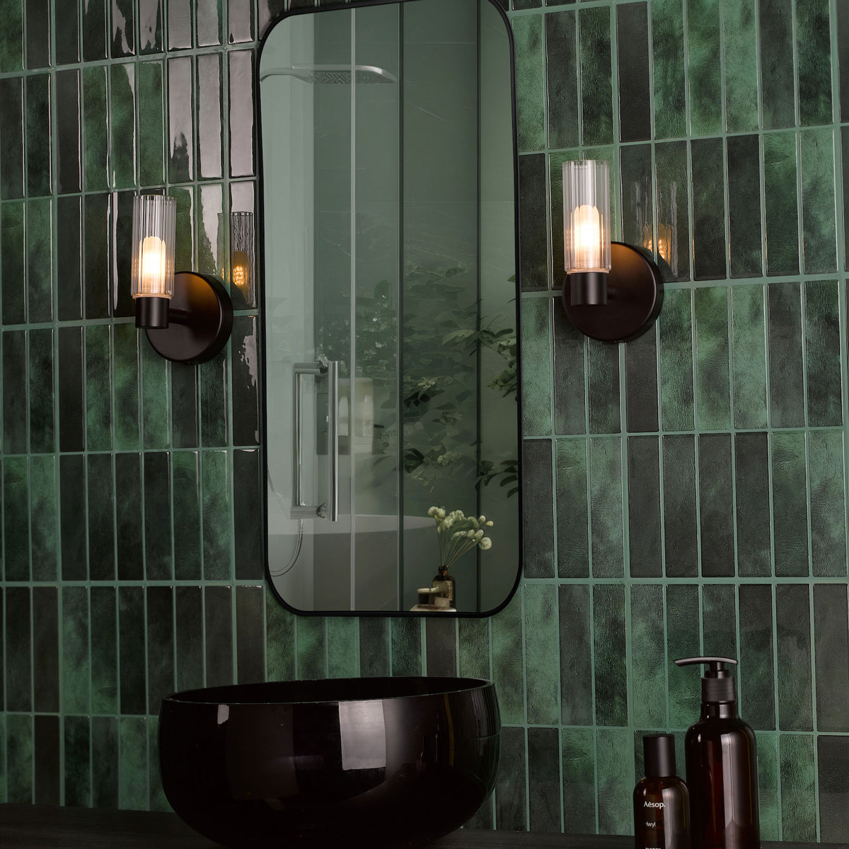 Bathroom with dark green subway tiles, black mirror, black basin, and two wall-mounted lights