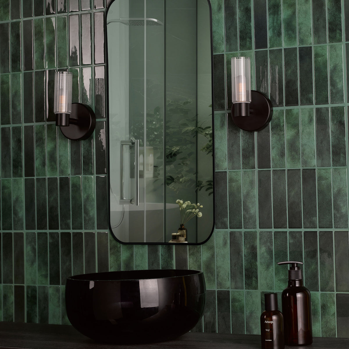 Bathroom with dark green subway tiles, black vessel sink, and a rectangular mirror