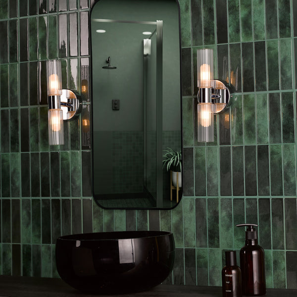 Bathroom with dark green subway tiles, black sink, mirror, and two wall-mounted lights