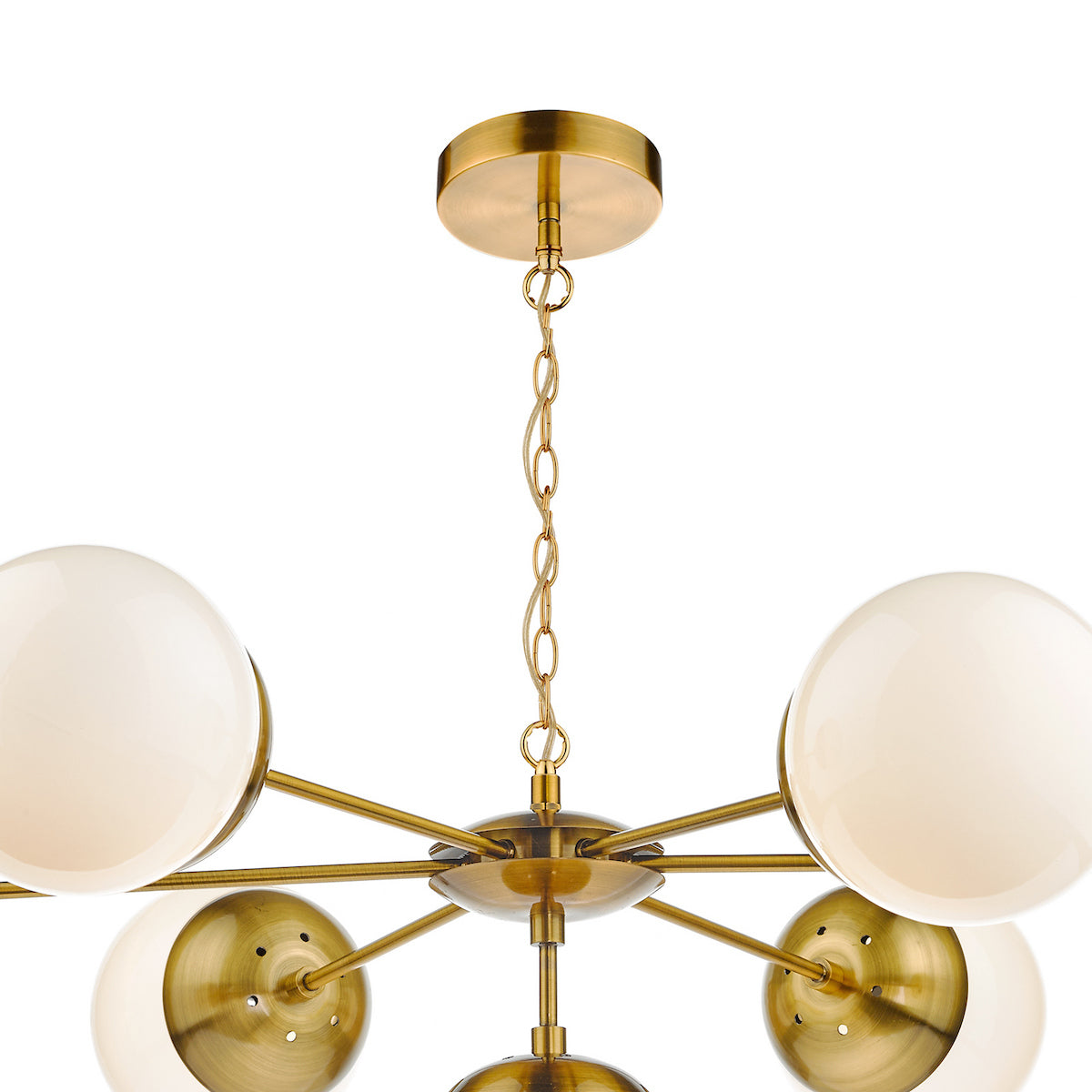 A close-up of a brass chandelier with white globe lights, hanging from a chain.