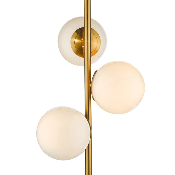 Three spherical glass shades on a brass pole, two illuminated and one with a brass cap