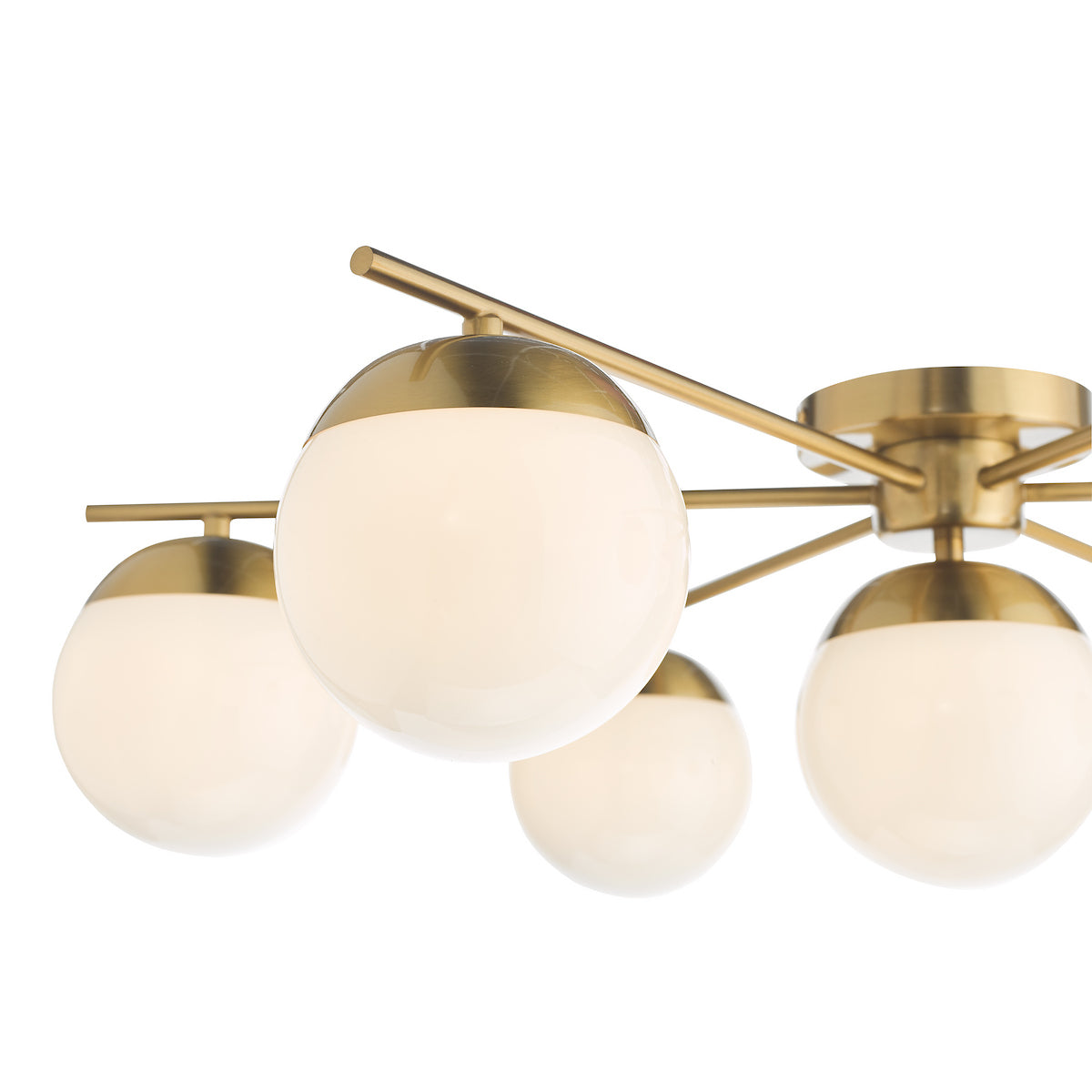 Close-up of a modern brass chandelier with five spherical white glass shades.