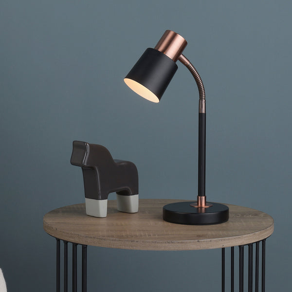 Black and copper desk lamp with a dark gray decorative horse on a wooden side table.
