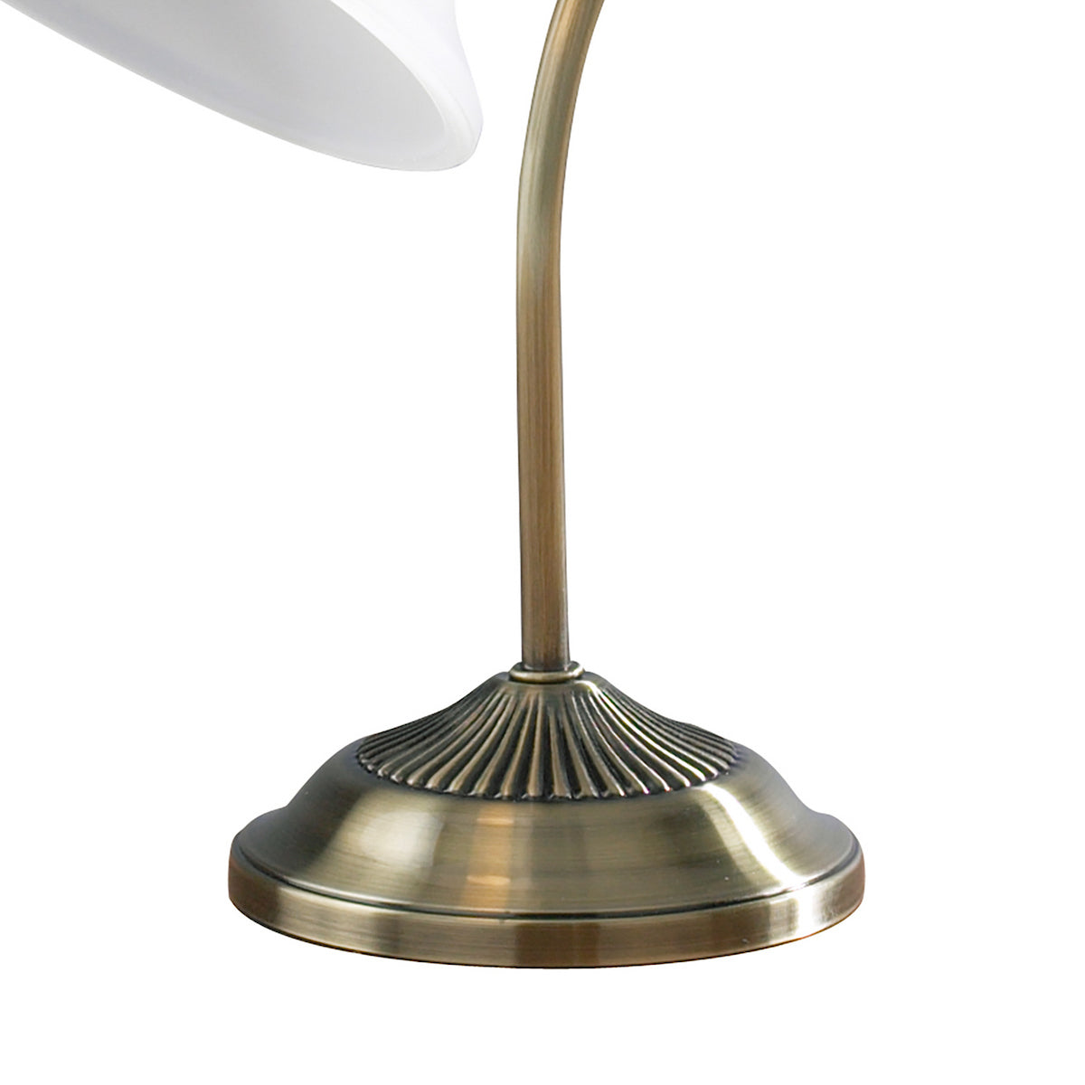 Close-up of a vintage brass lamp base with a fluted design and a curved stem.