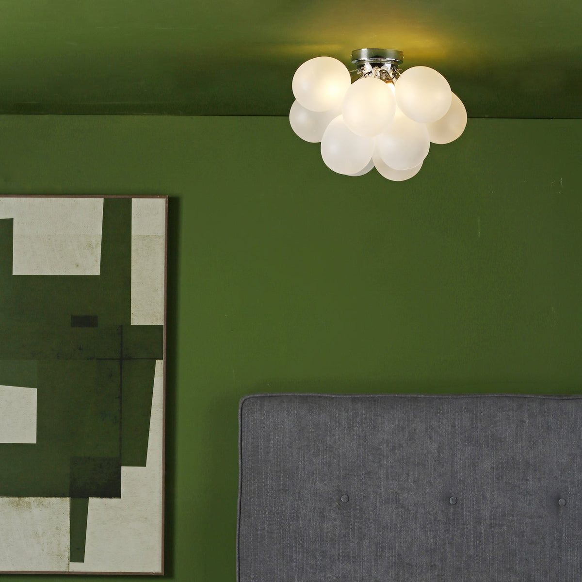 Bubble ceiling light with a green wall and a grey headboard