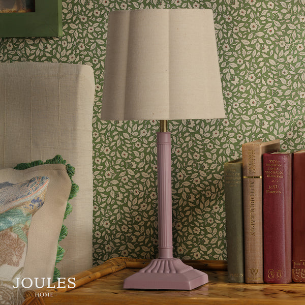 Joules Home table lamp with a pink fluted base and beige fabric shade on a wooden bedside table