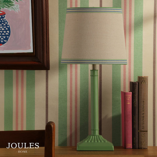 Joules Buscot table lamp in matt green with a tapered linen shade on a wooden surface
