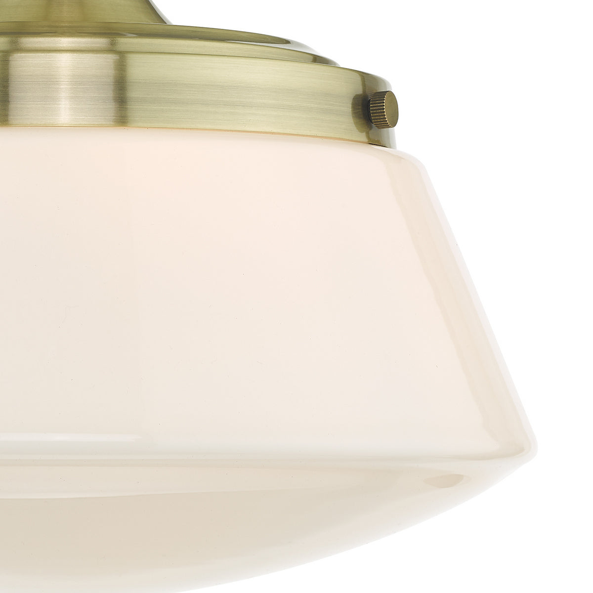Close up of a light fixture with a brass base and an off-white tapered glass shade