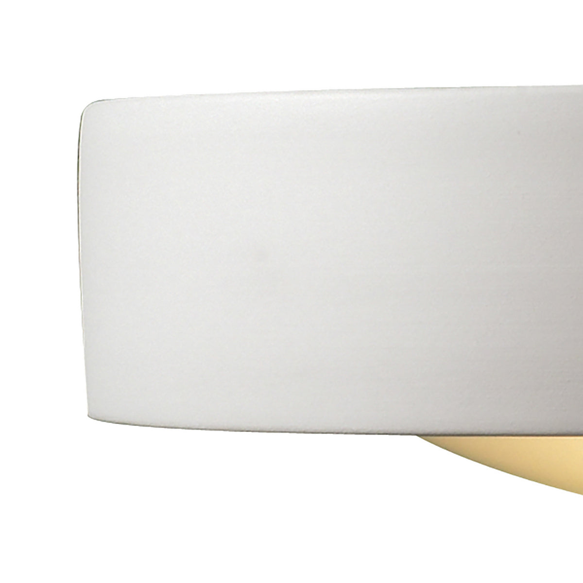 Close-up of a white lampshade with a golden base, casting a soft glow.