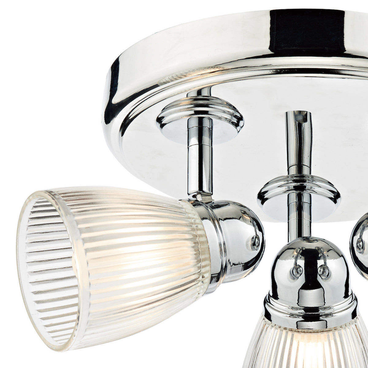 Close-up of a chrome ceiling light with three ribbed glass shades, one illuminated.