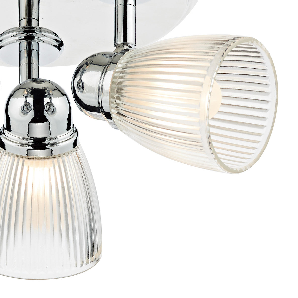 Close-up of two chrome and ribbed glass light fixtures with warm glow.