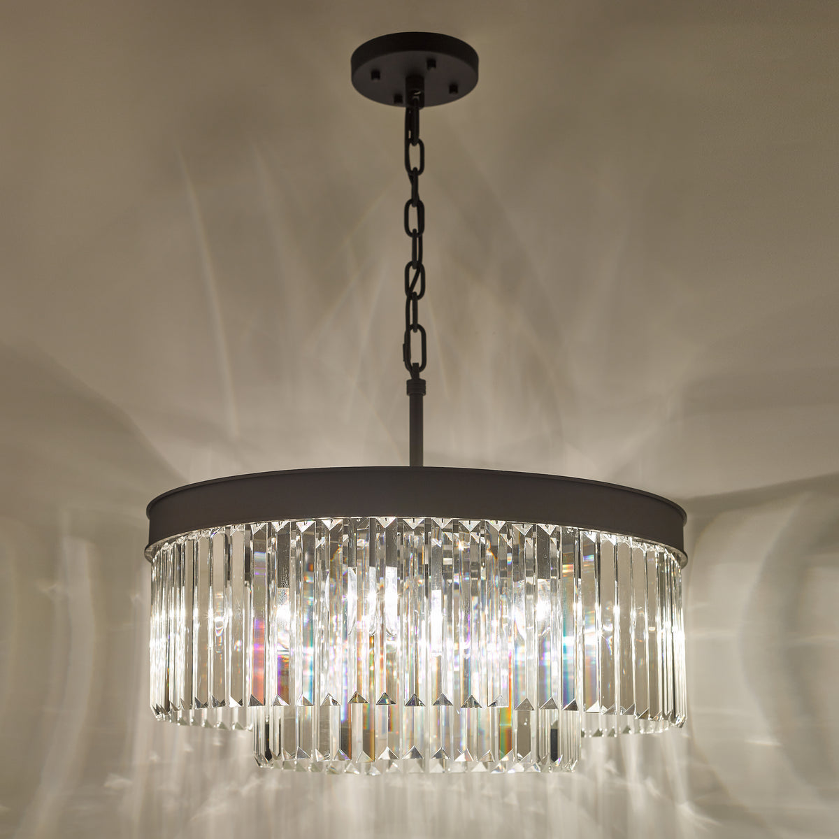 Round chandelier with a dark metal frame and clear crystal rods hanging from a chain