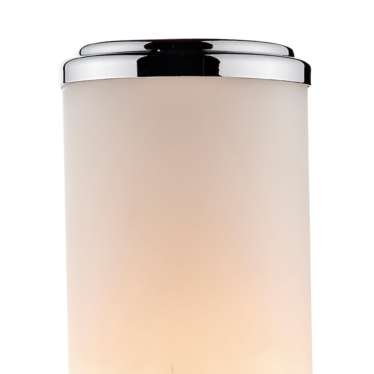 Close-up of a frosted glass cylinder with a chrome top, emitting a warm glow from within.
