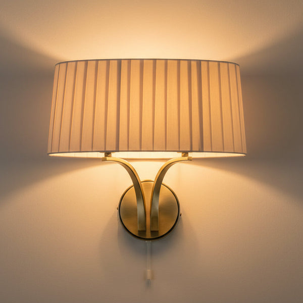 Wall mounted light fixture with a pleated fabric shade and a brass base