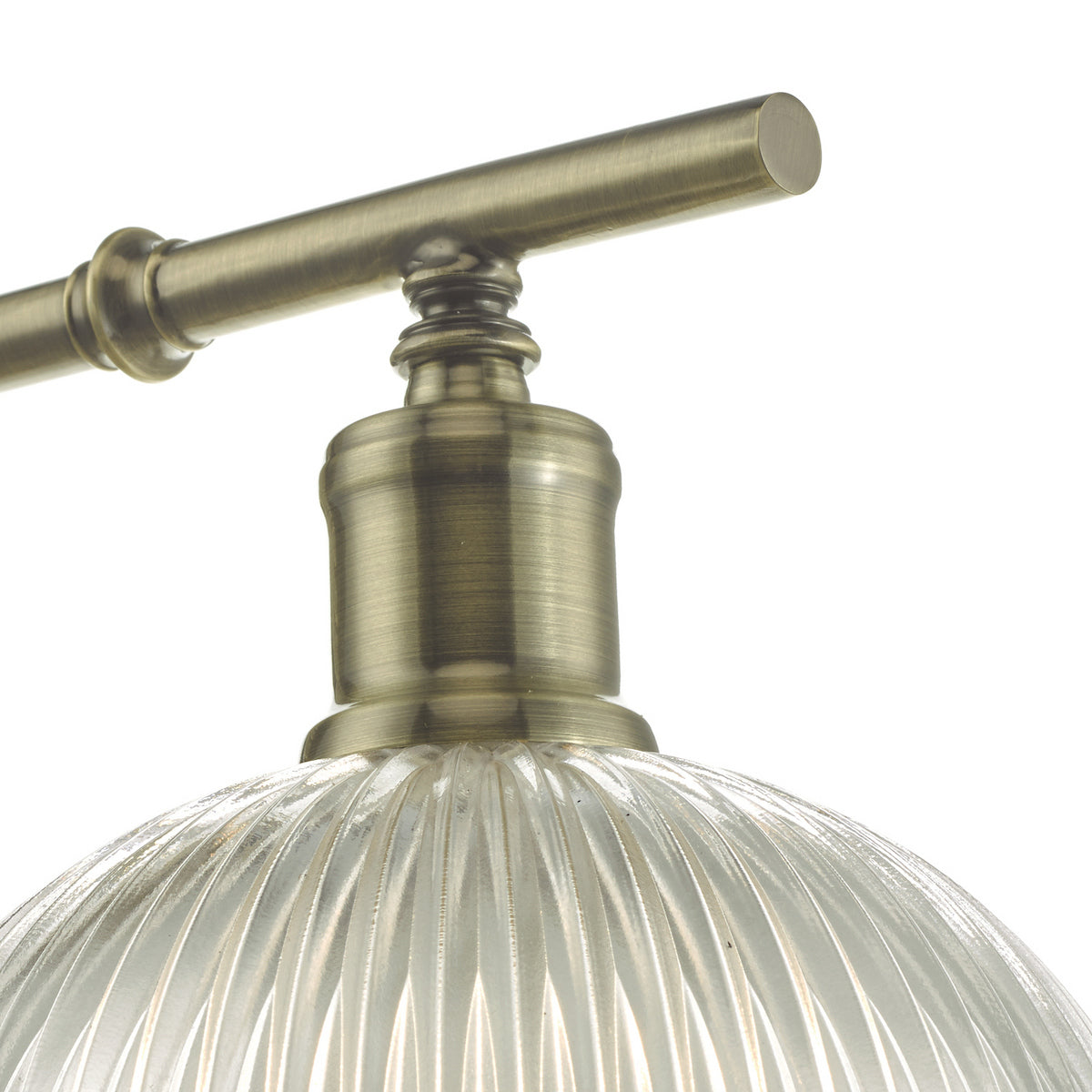 Close-up of a brass light fixture with a ribbed glass shade.