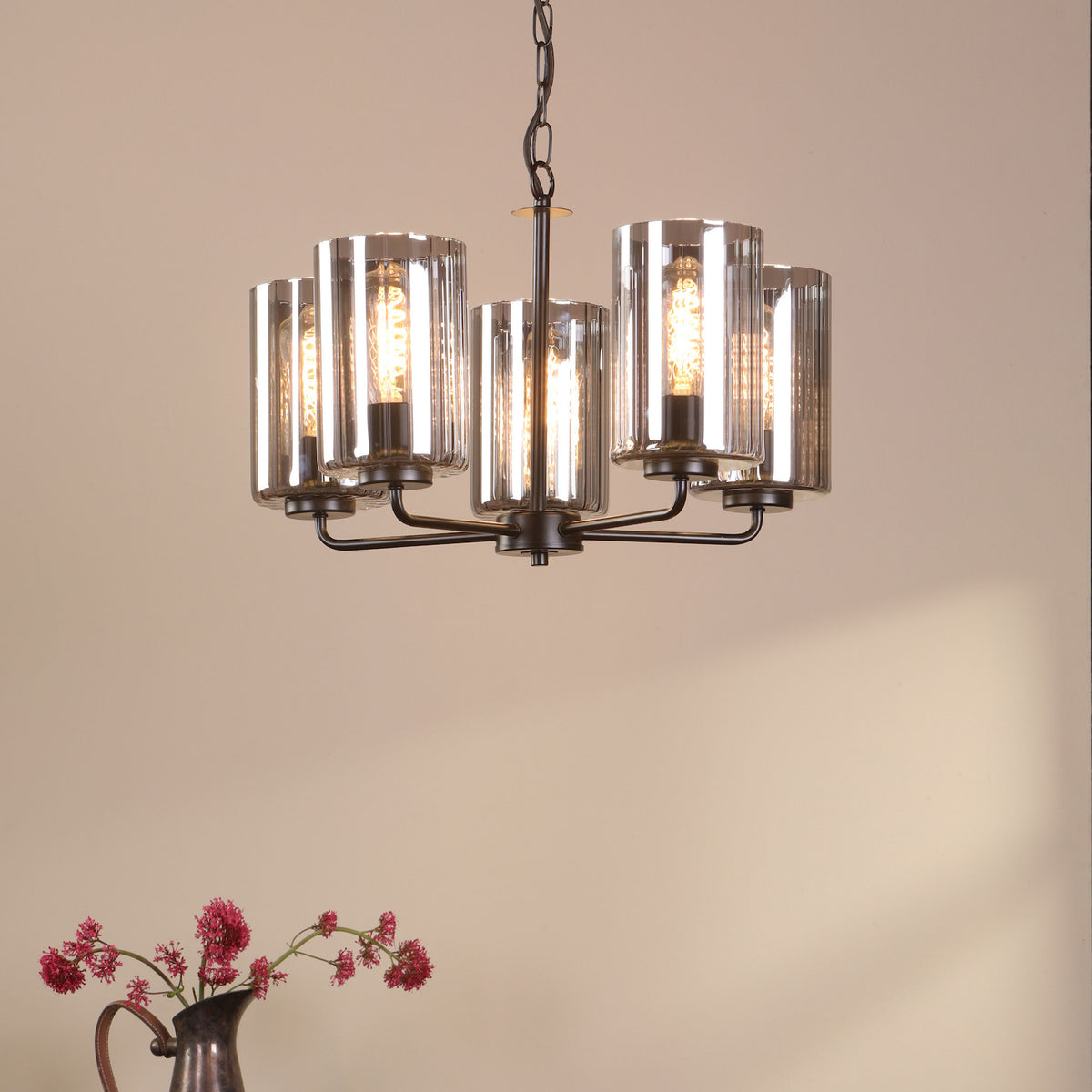 Five-light chandelier with clear glass shades and exposed filament bulbs