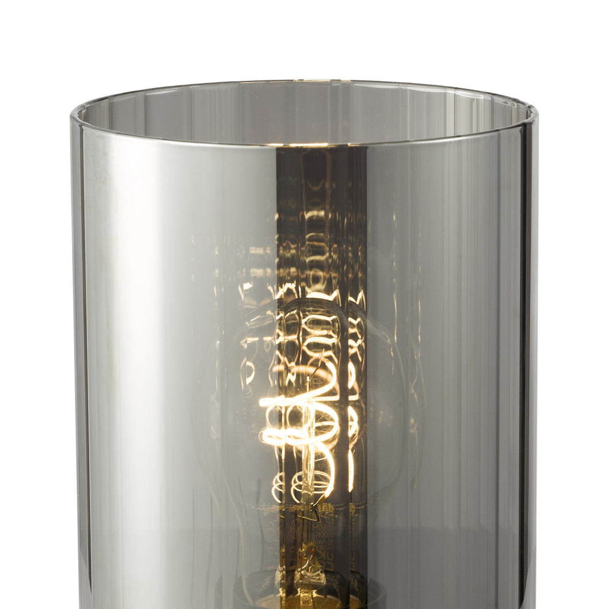 Close up of a lit lightbulb with a spiral filament inside a cylindrical smoked glass shade