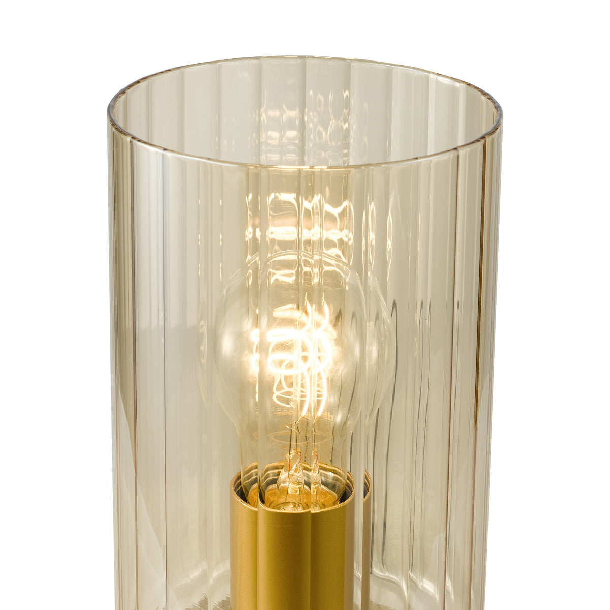 Close up of a ribbed glass lamp shade with a glowing bulb inside