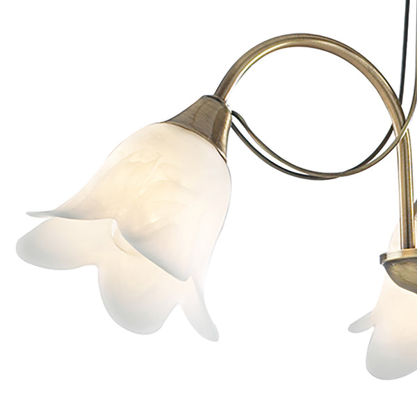 Close-up of a brass chandelier with two white, bell-shaped glass shades, illuminated against a white background.