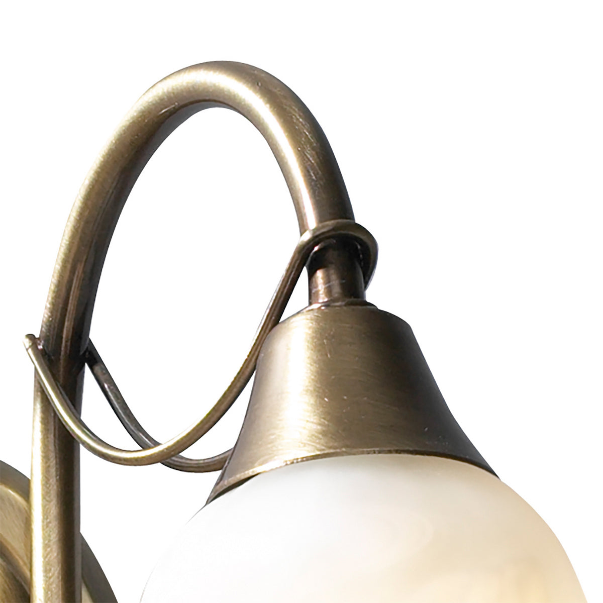 Close-up of a bronze wall sconce with a curved arm and a frosted glass shade.