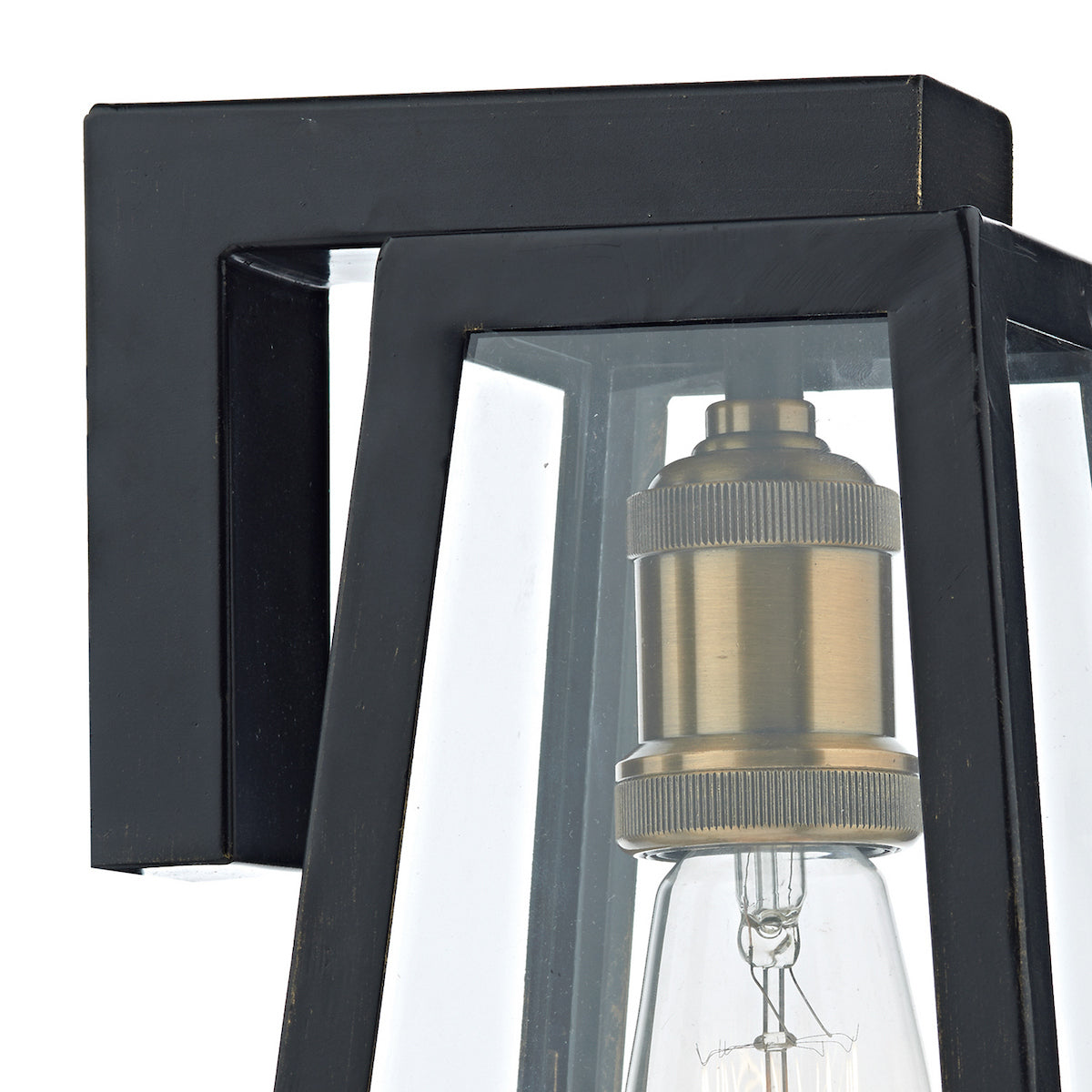 Close-up of a black outdoor wall light with clear glass panels and a brass bulb holder.