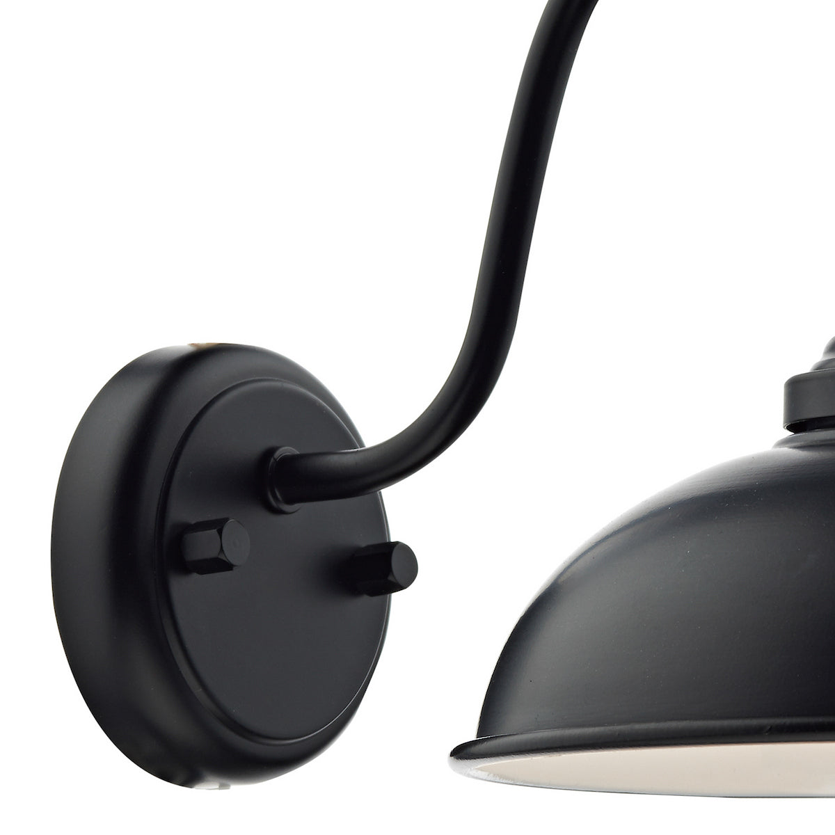 Close up of a black wall light with a curved arm and a dome-shaped shade